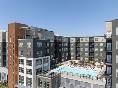 A large building with a pool in front of it.