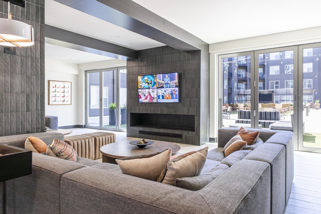 A living room with a grey couch and a television.
