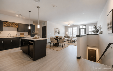 A modern kitchen with a dining area and a staircase.