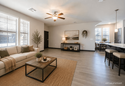 A living room with a white couch, a coffee table, and a ceiling fan.