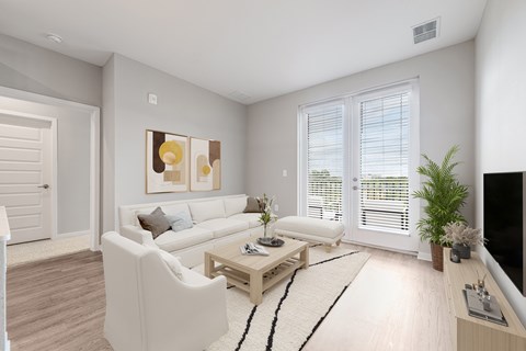A living room with a white couch, a coffee table, and a painting on the wall.