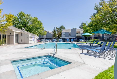 A large outdoor swimming pool with a slide and sun loungers.