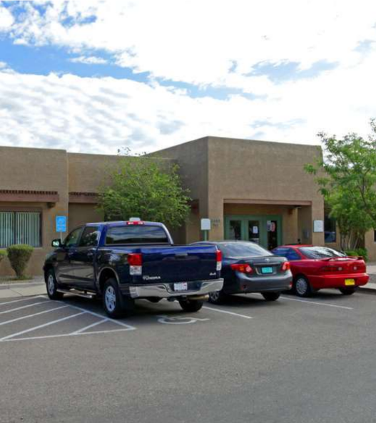 A black pickup truck is parked in a parking lot in front of a building.
