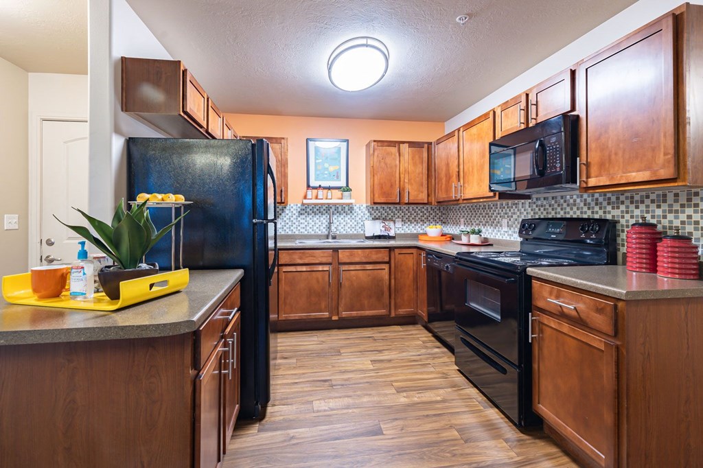 a kitchen with black appliances and wooden cabinets