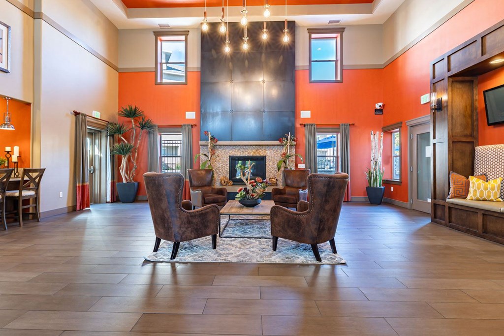 a lobby with chairs and a table with a fireplace