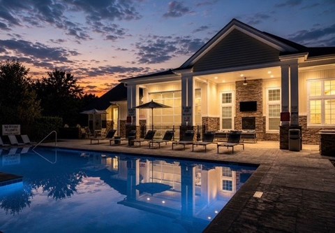 A house with a pool in front of it.