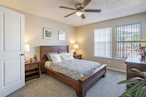 a bedroom with a bed and a ceiling fan