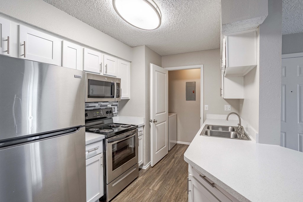 a kitchen with stainless steel appliances and white cabinets