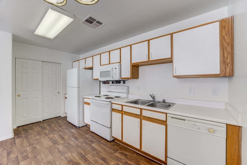 a kitchen with white appliances and wooden cabinets