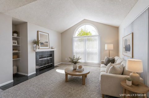 A living room with a fireplace, a couch, a coffee table, and a painting on the wall.