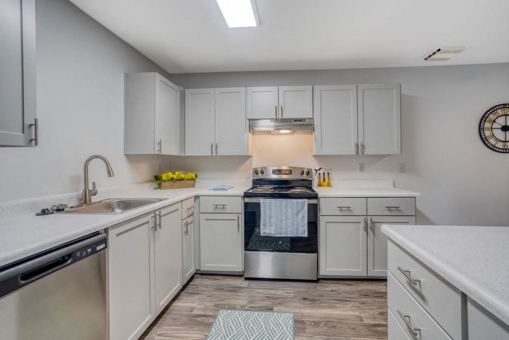 a white kitchen with stainless steel appliances and white cabinets