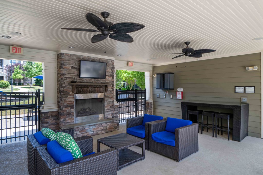 Outdoor lounge with couches and a fireplace
