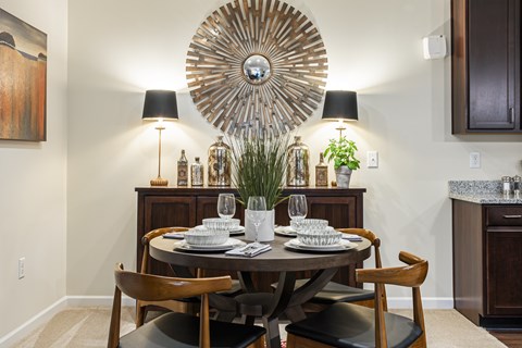 A dining room with a round table set for two.