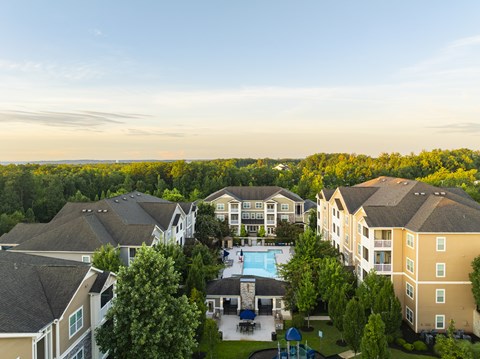 A large apartment complex with a pool in the middle.