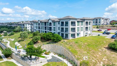 A large apartment complex with a parking lot in front.