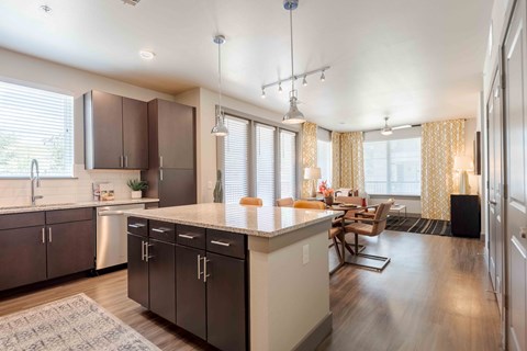 A modern kitchen with dark brown cabinets and a white countertop.