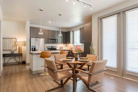 A modern kitchen with a dining table set for four.