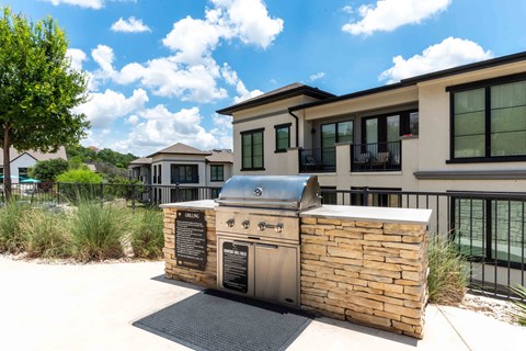 A modern outdoor kitchen with a grill and sink.