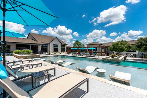 A sunny day at the pool with a blue umbrella.