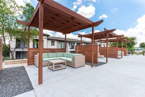 A wooden pavilion with a bench underneath it.