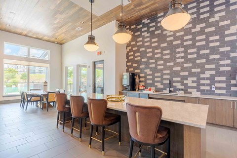 A kitchen with a bar area and chairs.
