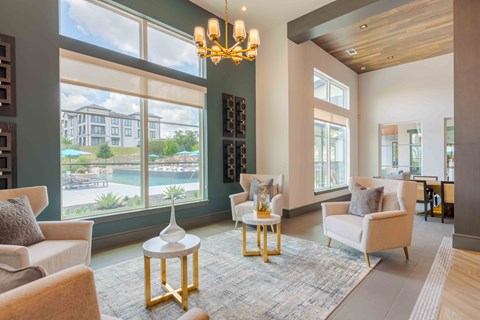 A living room with a large window and a view of a building.