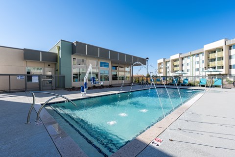 A swimming pool and a building in the background.