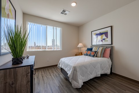 A bedroom with a large bed and a view of the city.