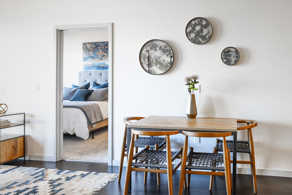 a dining room with a table and chairs and a bedroom with a bed