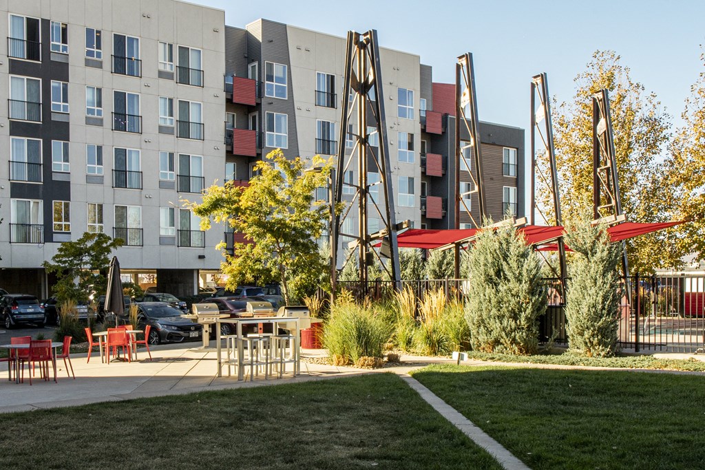 an outdoor area with tables and chairs in front of an apartment building