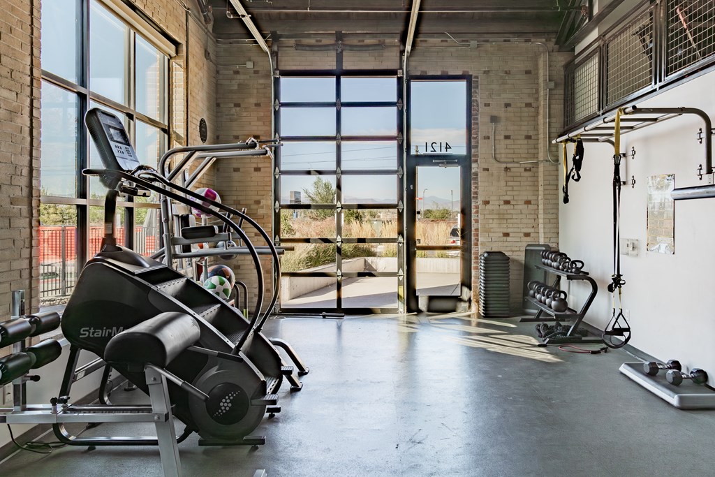 a gym with a lot of exercise equipment and windows