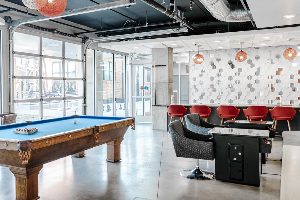 a game room with a pool table and a bar