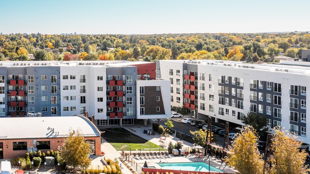 an aerial view of the apartment complex with trees in the background