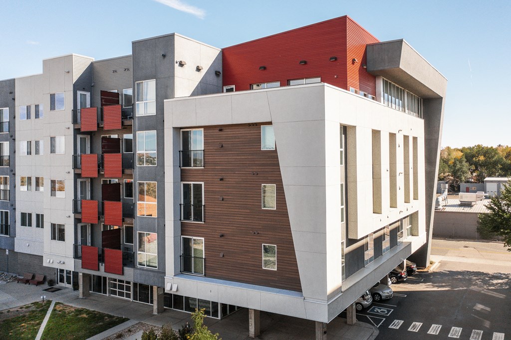 a modern apartment building with red and white facade and balconies