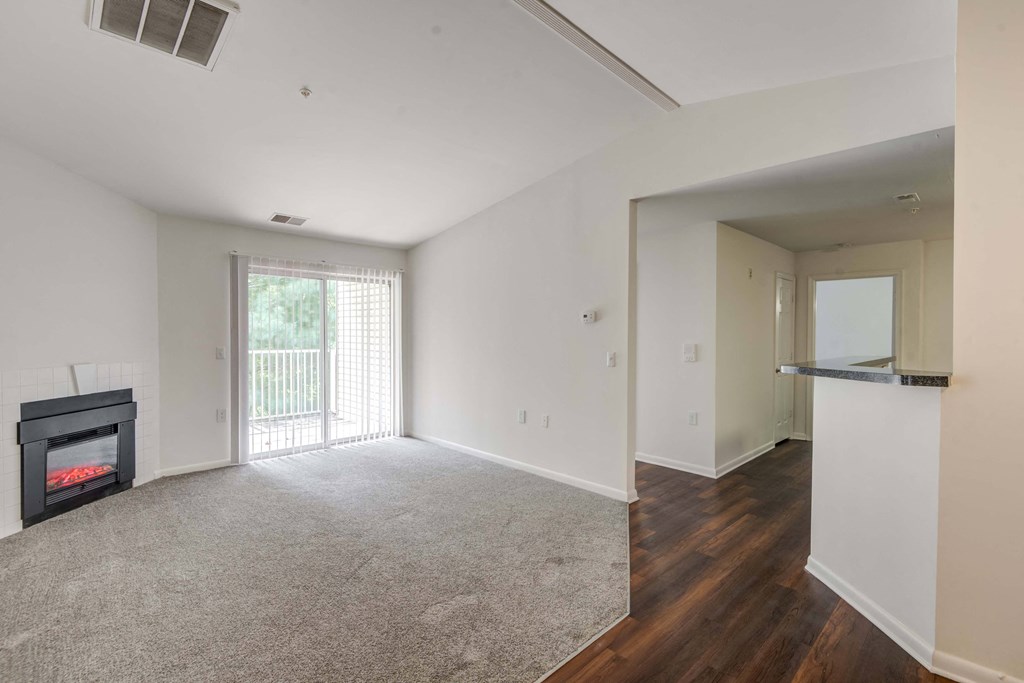a living room with a fireplace and a door to a balcony