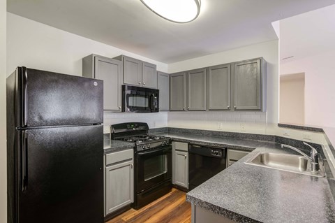 a kitchen with granite counter tops and black appliances