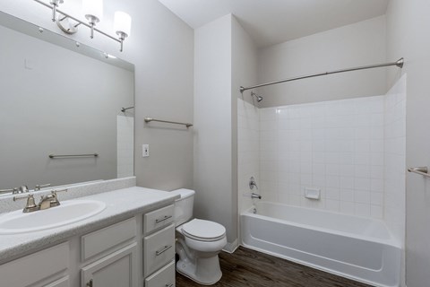 an empty bathroom with a toilet and a tub and a sink