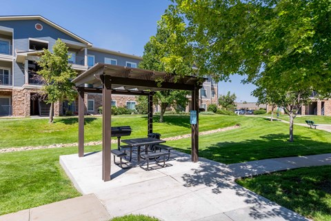 a picnic pavilion with a picnic table on a sidewalk