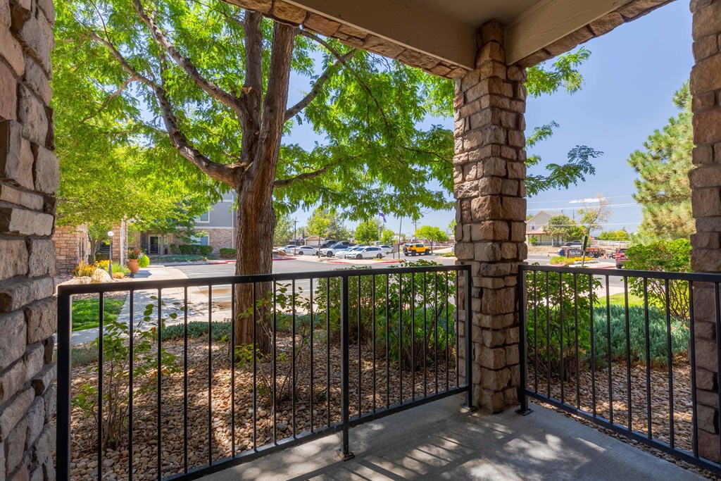 a balcony with a tree and a wrought iron fence