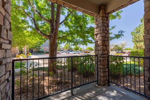 a balcony with a tree and a wrought iron fence