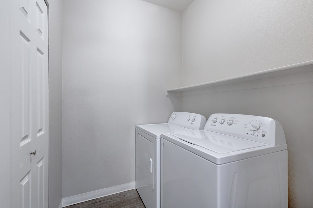 a white washer and dryer in a room with a white wall and door