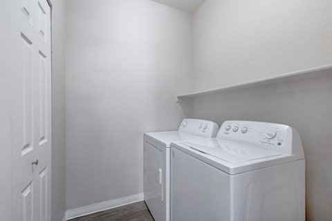 a white washer and dryer in a room with a white wall and door