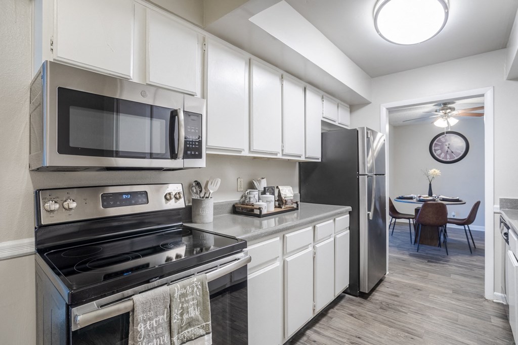 a kitchen with stainless steel appliances and white cabinets