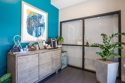 a lobby with a reception desk and a blue wall and glass doors