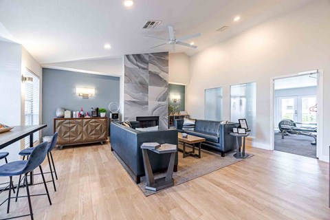 A modern living room with a grey sofa and a wooden floor.