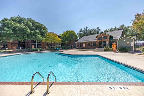 A large swimming pool with a building in the background.