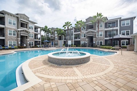 A swimming pool with a fountain in the middle of a residential area.