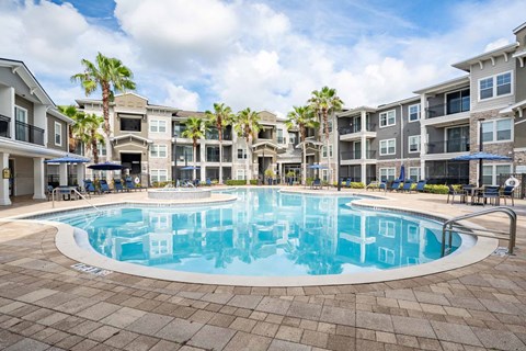 A large swimming pool in front of apartment buildings.