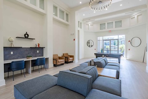 A living room with a grey sofa set and a black and white shelf.