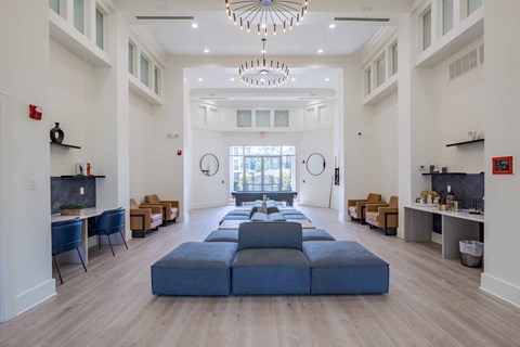 A large open living room with a long blue sofa in the middle.